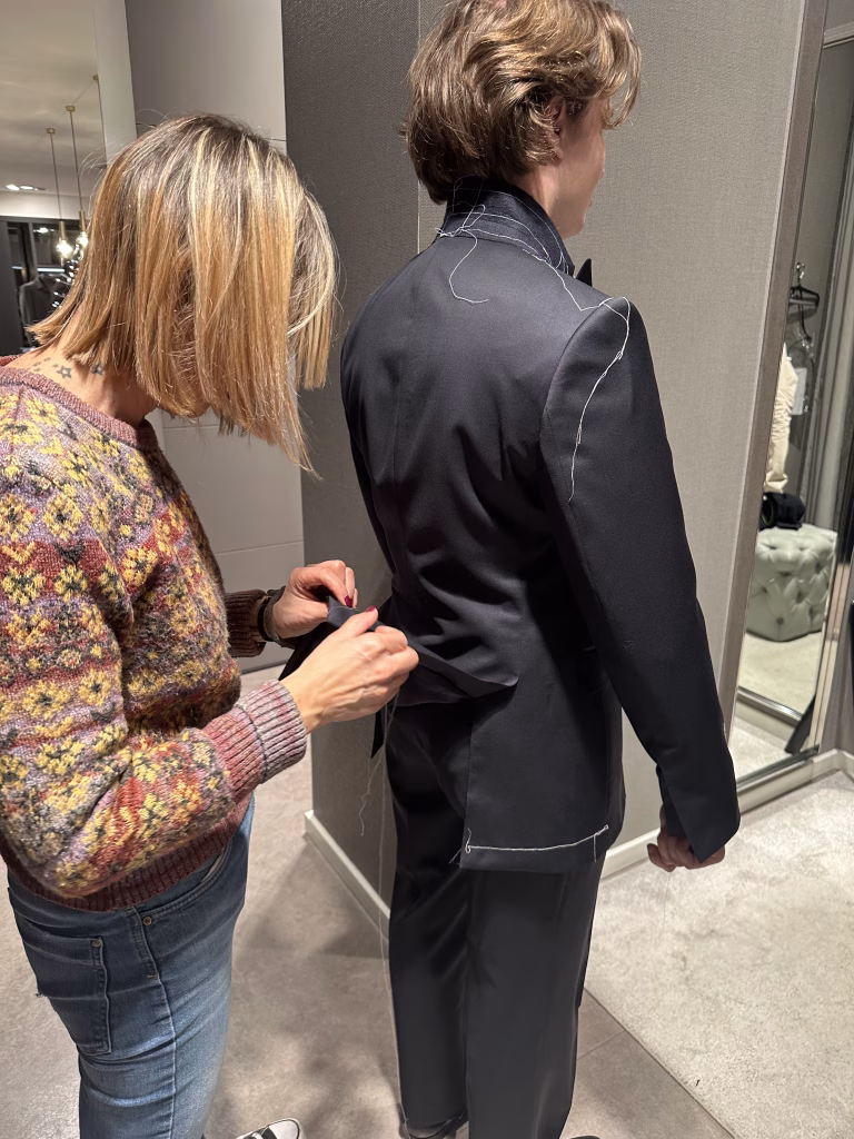 Costureira a ajustar as costas de um casaco de fato clássico da Crialme.